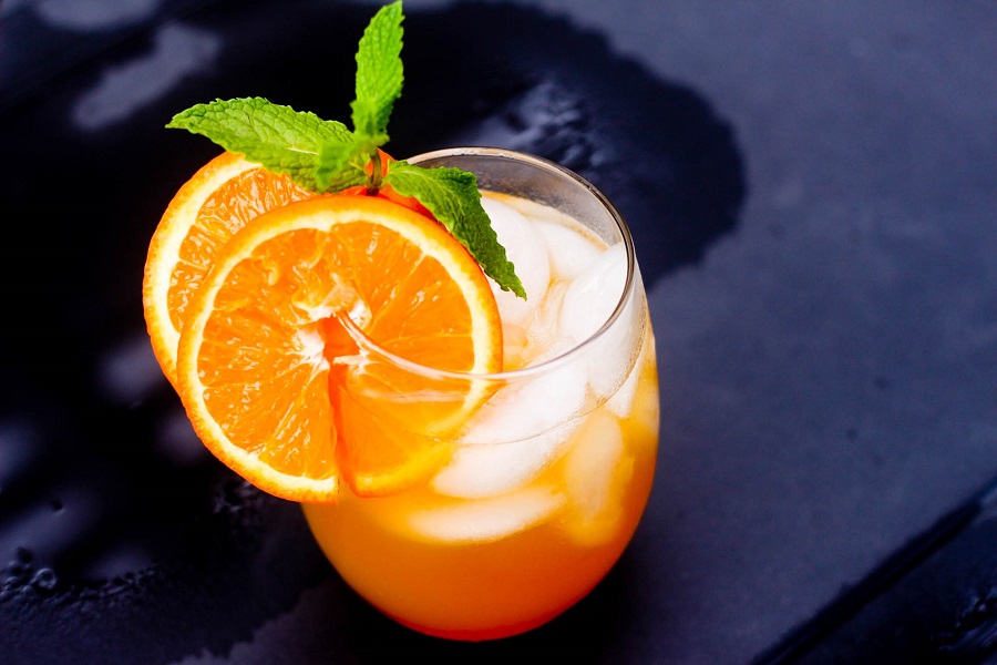 A Fireball Whisky Cocktail with Passion Fruit Sitting on a Black Surface