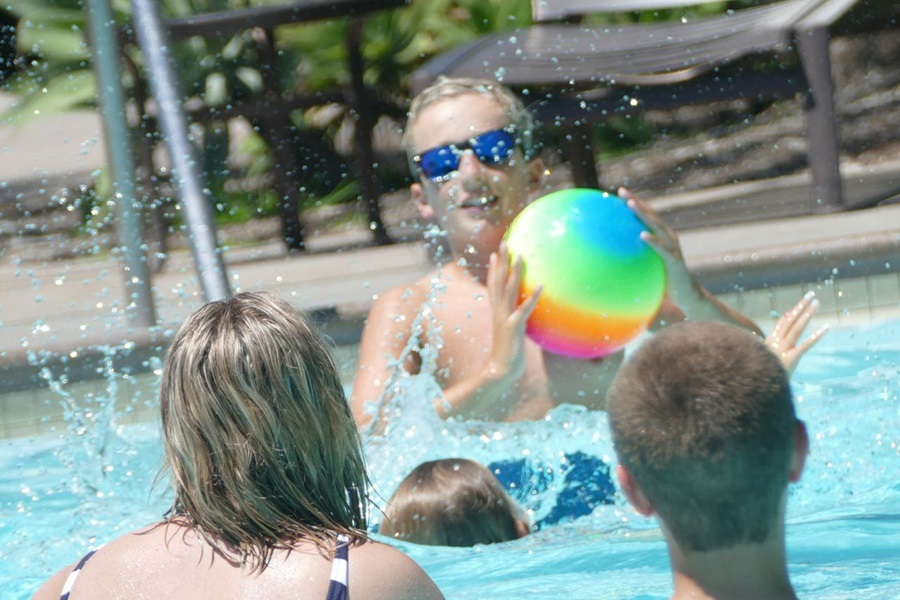 Panasonic Lumix FZ1000 Tips and Tricks Kids Playing with a Rainbow-Colored Ball in a Pool