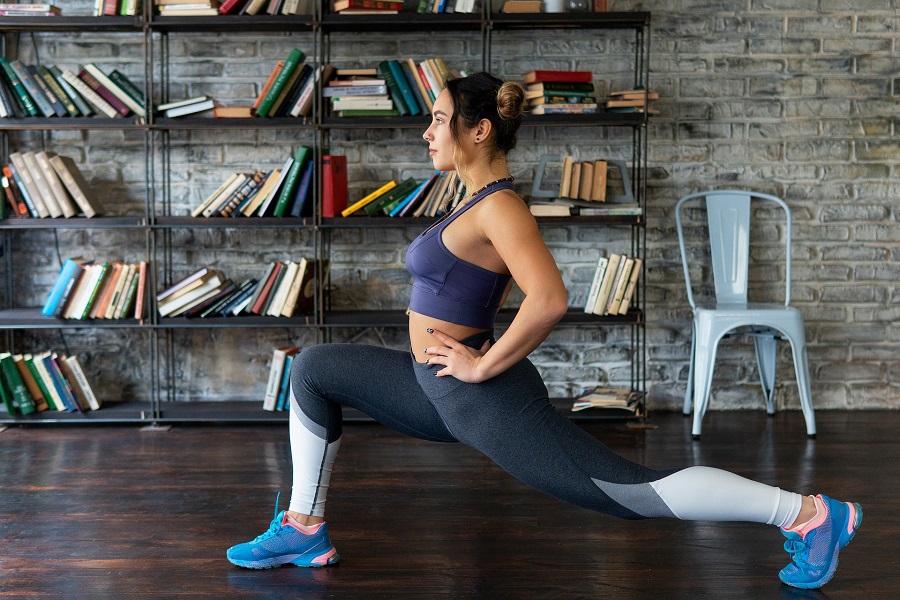 At Home Tabata Workouts for Beginners Woman Doing a Lunge in Front of a Bookshelf.