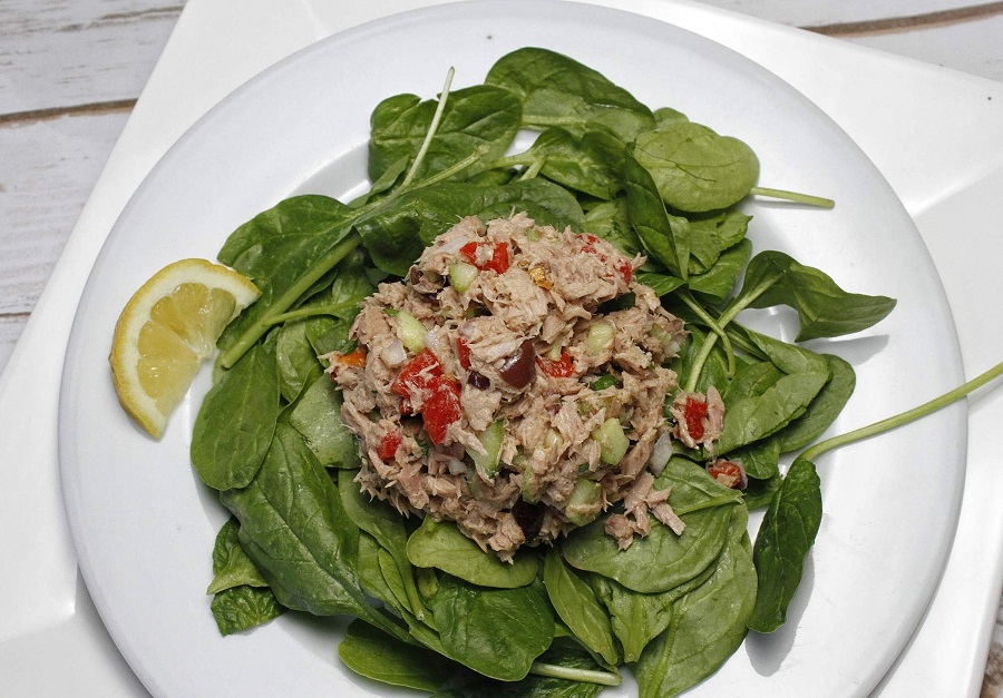Overhead View of Mediterranean Tuna Salad on a Bed of Spinach.