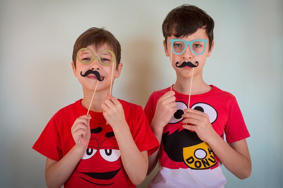 5 April Fools Jokes for Young Kids Two Young Boys Holding Play Masks on Sticks Up to Their Faces