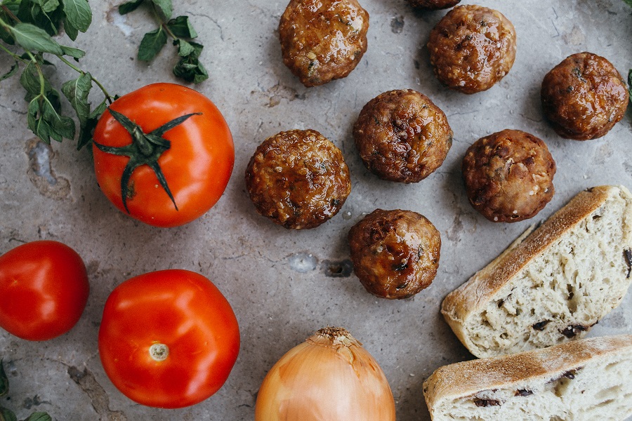 Dairy Free Dinner Recipes Meatballs Next to Two Tomatoes an Onion and a Couple of Slices of Bread