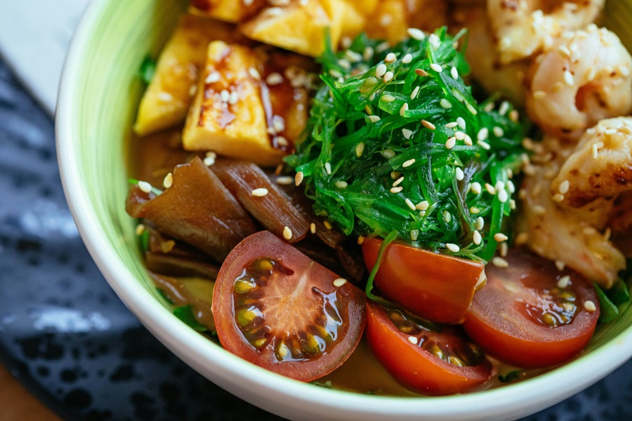 What Can You Eat on a Pegan Diet Close Up of a Salad with Seaweed, Tomatoes, and Squash