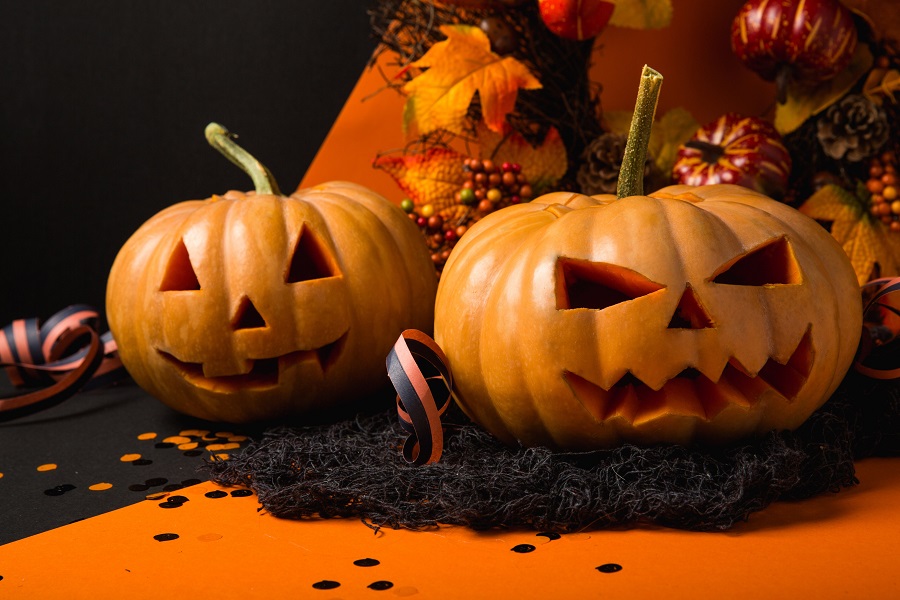 Spooky Halloween Crockpot Recipes Close Up of Two Jack-O-Lanterns Surrounded by Halloween Decorations
