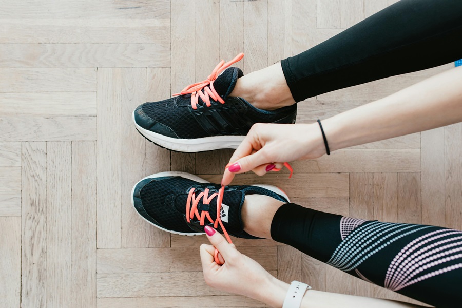 35 At Home Workouts for Women Close Up of a Woman's Legs as She Ties Running Shoes on