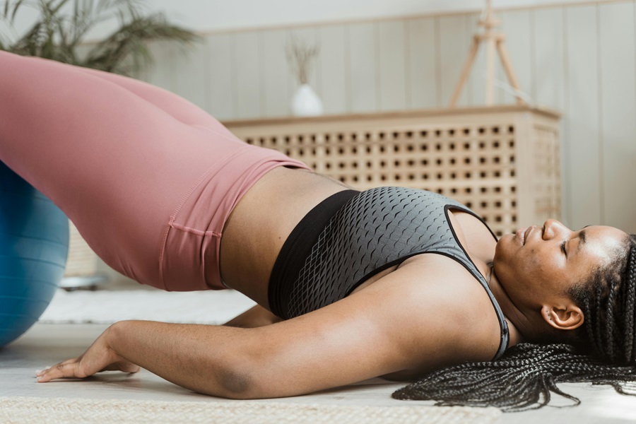 35 At Home Workouts for Women a Woman Lying on the Ground Doing Hip Thrusts