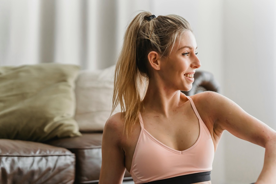 35 At Home Workouts for Women a Woman Wearing Workout Clothes Sitting in a Living Room